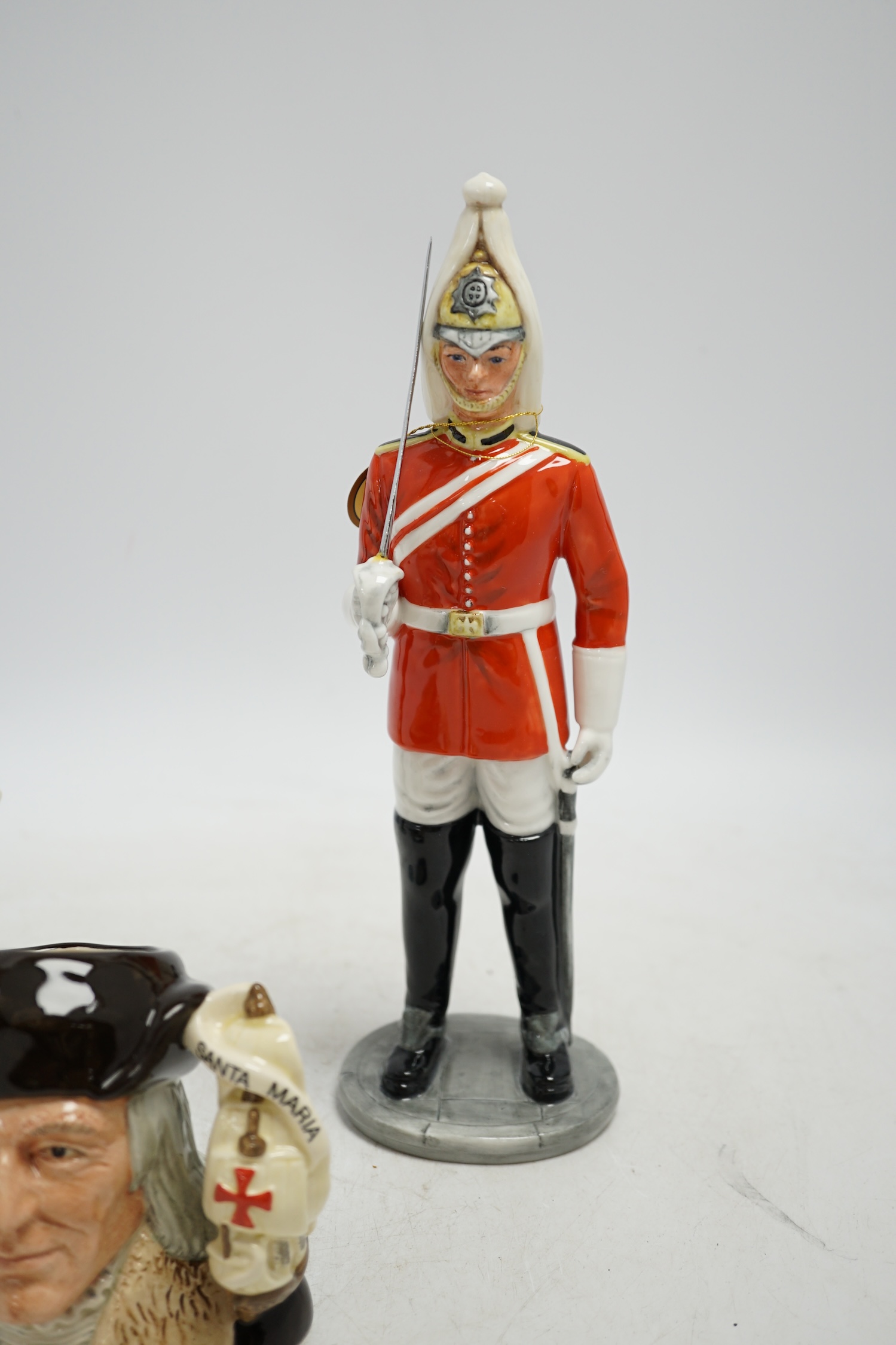 Six Royal Doulton figures including Bunny’s Bedtime, The Guardsman and The Lifeguard, together with a Christopher Columbus Toby jug, all boxed, Guardsman 25cm high. Condition - fair to good